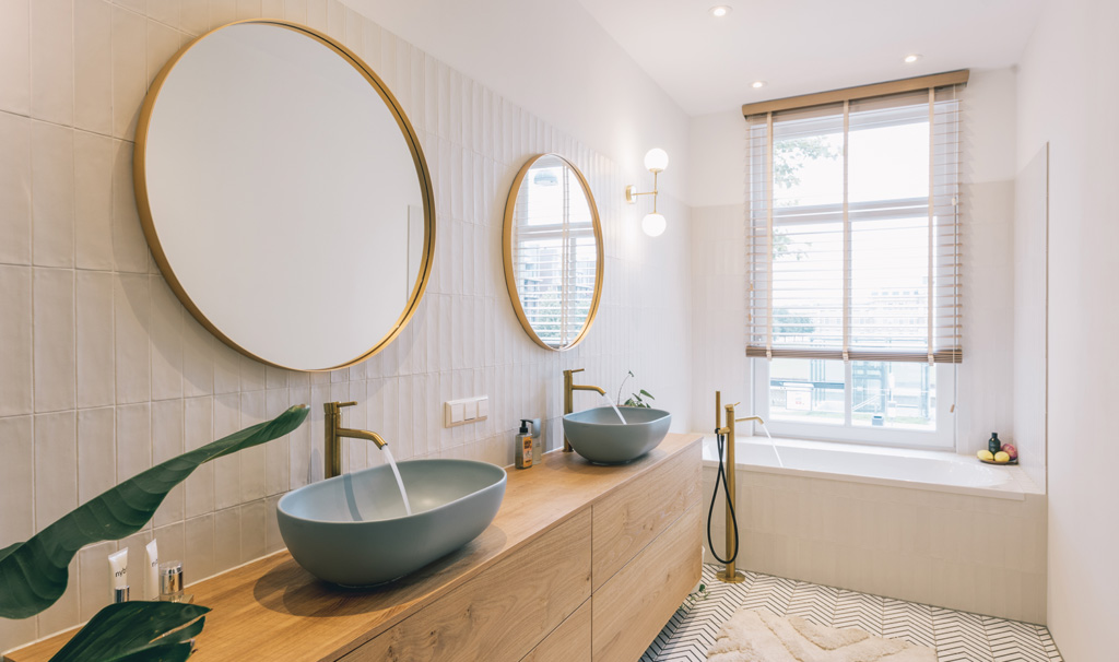 Edenbergs VVS badrumsrenovering – modernt badrum med dubbelhandfat och gulddetaljer